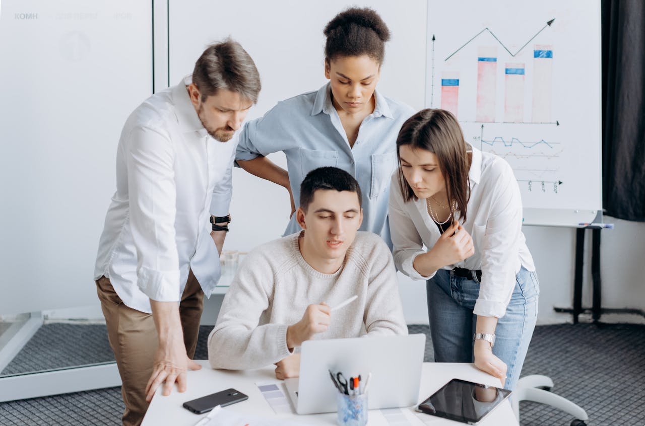Group of professionals collaborating on a project with graphs in an office setting.