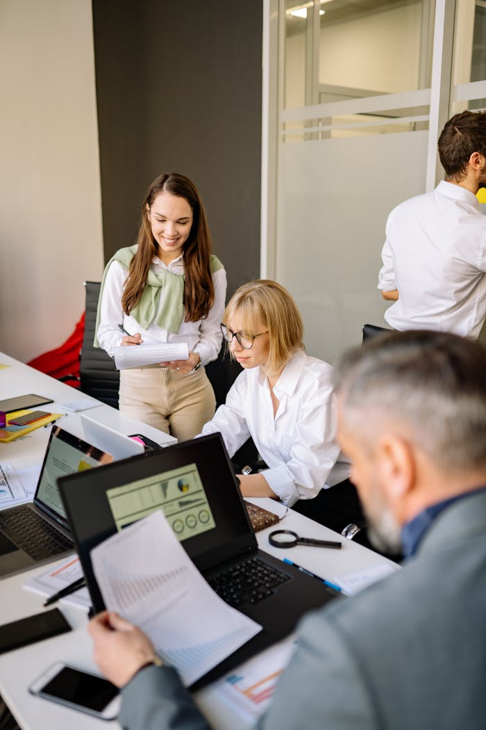 Colleagues collaborating on project in office setting, diverse team dynamics.